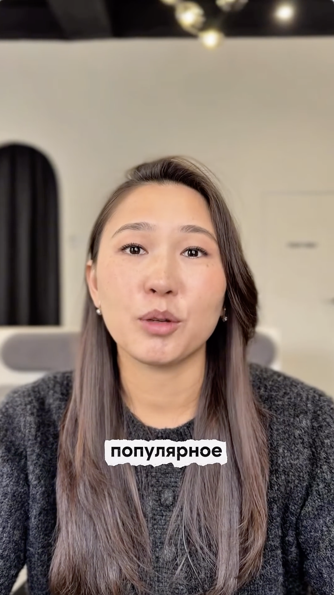 Founder pitch camp invitation opener: a face close-up of the founder in a grey sweater against a soft-lit interior, caption "популярное" on screen.