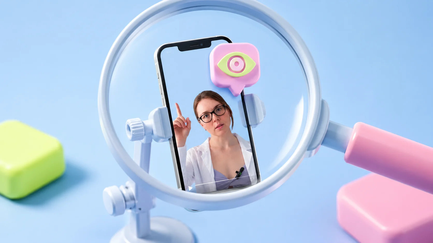 A vertical short video frozen on its first frame, held in a small clamp under a soft magnifying lens, with a soft-3D eye marker hovering over the opening frame. Light blue background with a pink-to-yellow-green glow. The image conveys inspecting the opener before it goes out.